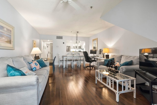 living room featuring ceiling fan with notable chandelier and dark hardwood / wood-style floors