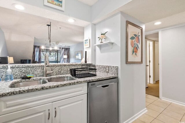 kitchen featuring white cabinetry, light stone countertops, sink, dishwasher, and light tile patterned floors