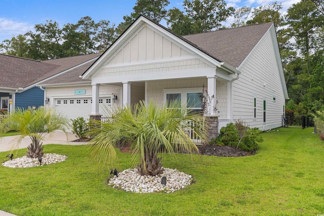 craftsman house featuring an attached garage, a shingled roof, a front lawn, and board and batten siding