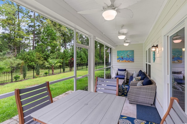 sunroom / solarium featuring a ceiling fan