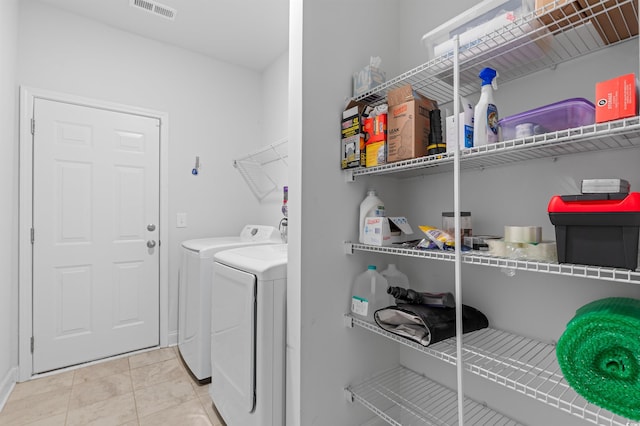 clothes washing area featuring light tile patterned floors, laundry area, visible vents, and washer and dryer