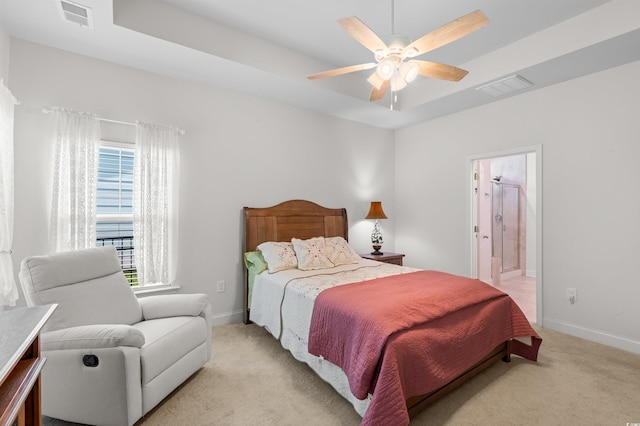 bedroom featuring light carpet, baseboards, visible vents, and a raised ceiling