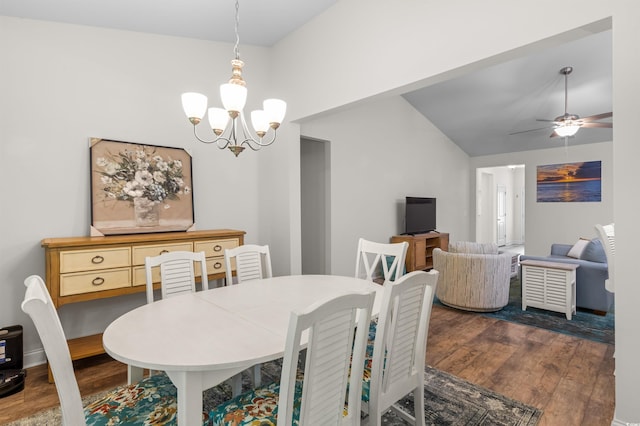 dining area featuring ceiling fan with notable chandelier, dark wood-type flooring, and lofted ceiling