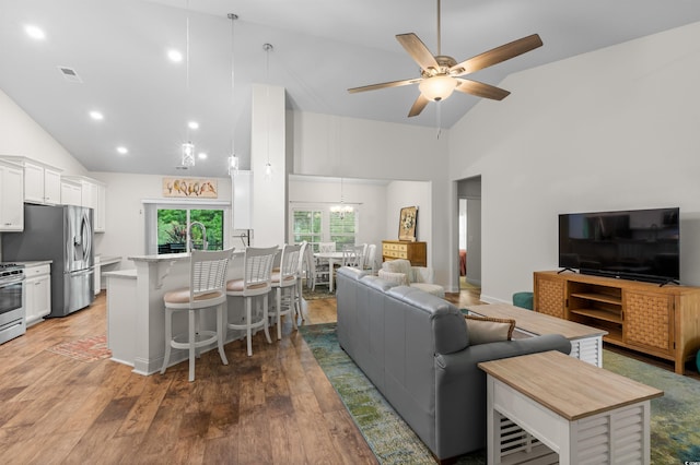 living area with ceiling fan, high vaulted ceiling, light wood finished floors, and recessed lighting