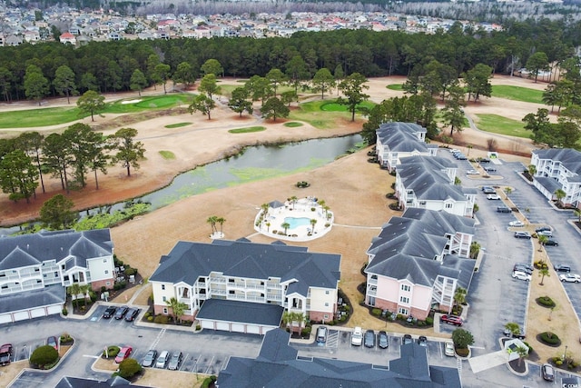 birds eye view of property with golf course view and a water view