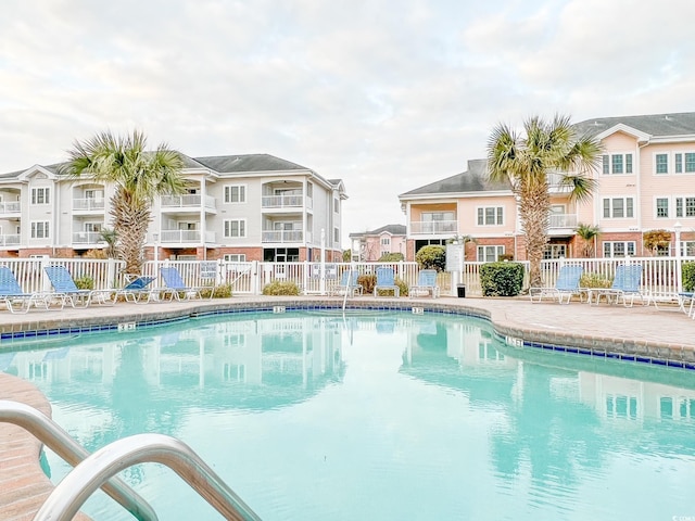 community pool with a patio and fence