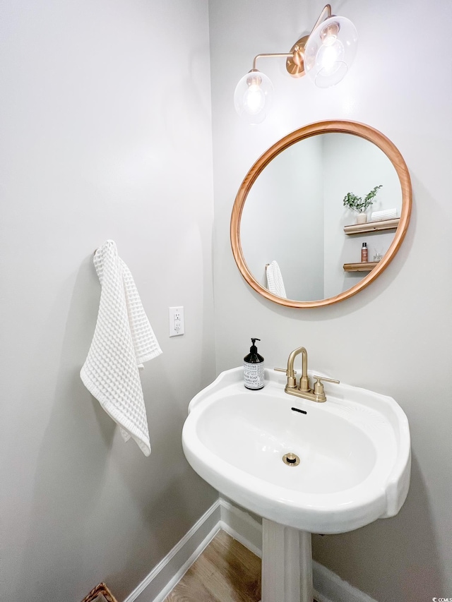 bathroom featuring a sink, baseboards, and wood finished floors