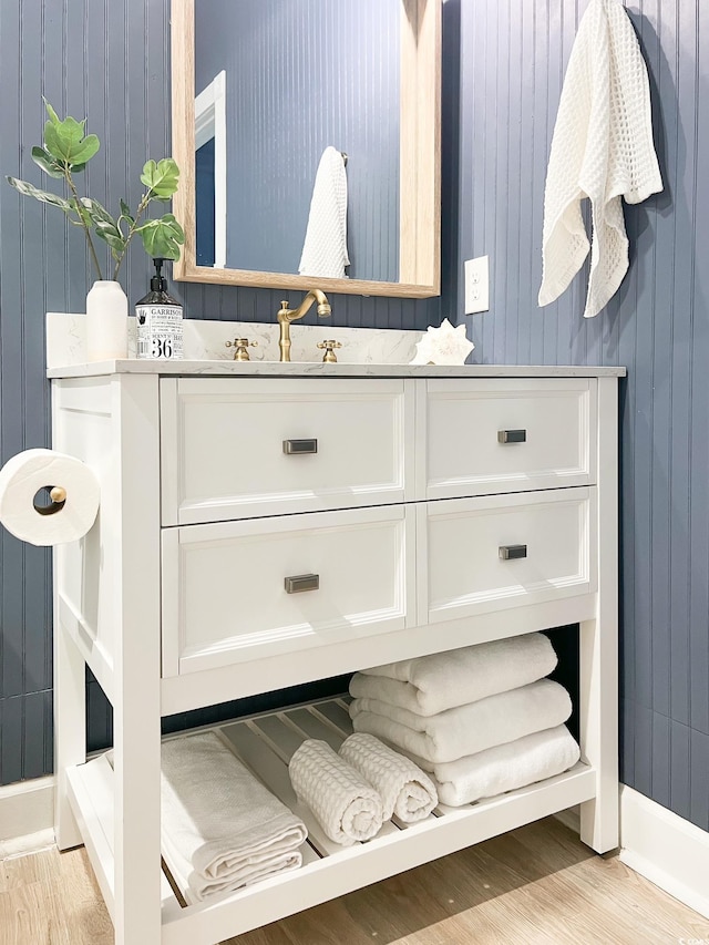 bathroom featuring baseboards, wood finished floors, and vanity