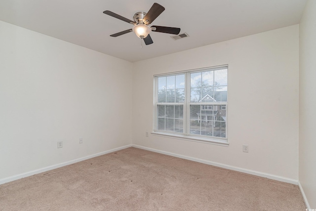 spare room with ceiling fan and light carpet