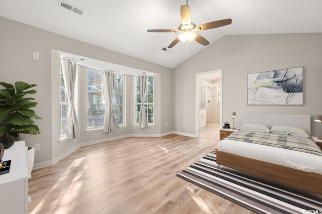 bedroom with ceiling fan, lofted ceiling, connected bathroom, and light hardwood / wood-style floors