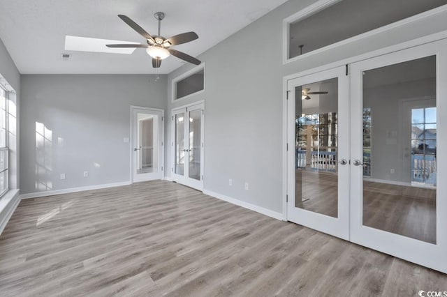 spare room featuring a wealth of natural light, light hardwood / wood-style floors, french doors, and ceiling fan
