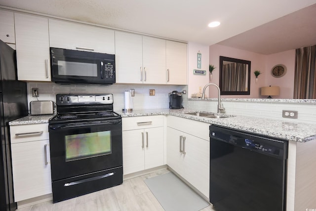 kitchen featuring tasteful backsplash, black appliances, sink, kitchen peninsula, and light stone countertops