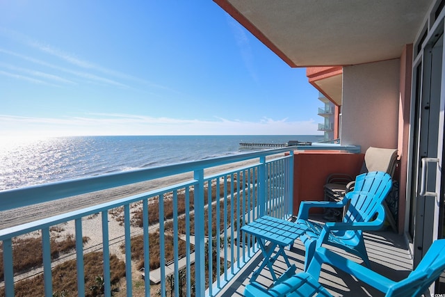 balcony featuring a water view and a view of the beach