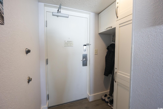 doorway to outside with dark hardwood / wood-style floors and a textured ceiling