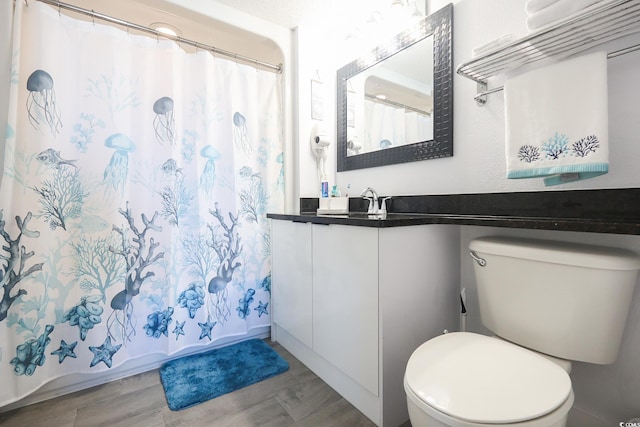 bathroom with hardwood / wood-style floors, toilet, and walk in shower