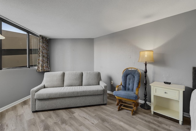 living area with light wood-type flooring and a textured ceiling