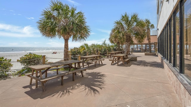 view of patio / terrace with a water view and a view of the beach