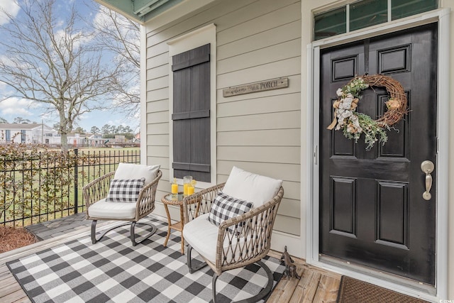 entrance to property with a porch and fence