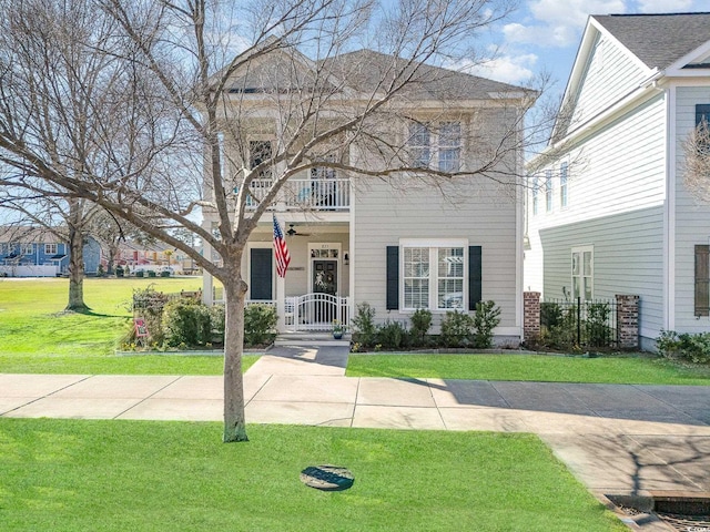 view of front of property featuring a front yard and a balcony