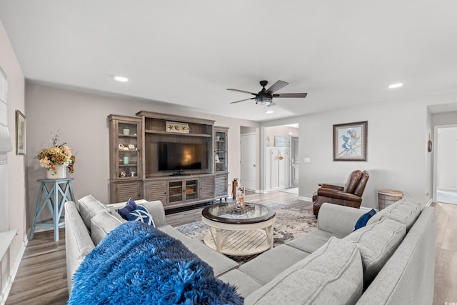 living room with ceiling fan and light hardwood / wood-style flooring