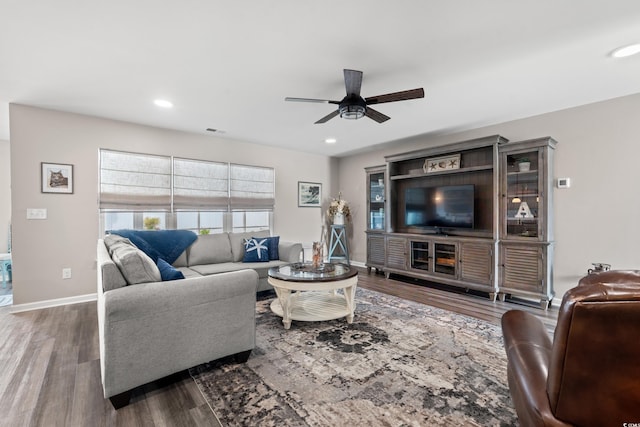 living room featuring ceiling fan and dark hardwood / wood-style floors