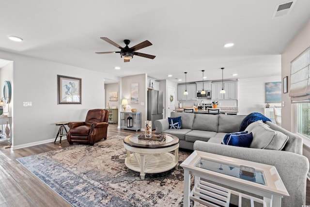 living room with ceiling fan and hardwood / wood-style floors