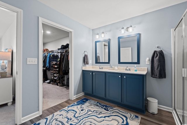 bathroom with hardwood / wood-style flooring, vanity, and a shower with shower door