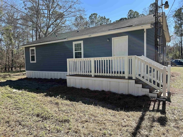 back of house with a yard and stairs