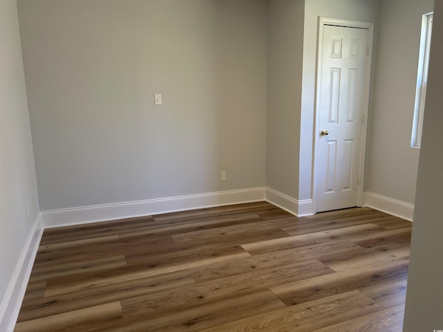 unfurnished room with baseboards and wood finished floors