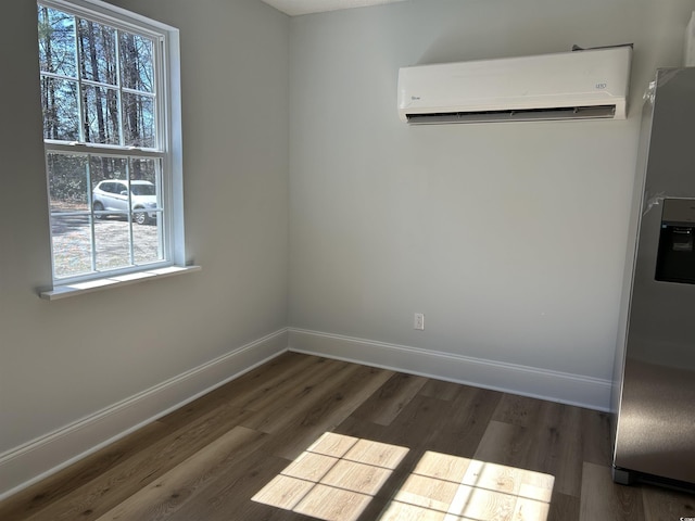 interior space with dark wood-style flooring, baseboards, and a wall mounted AC