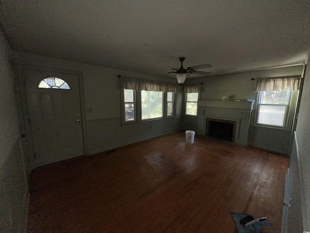 unfurnished living room with dark hardwood / wood-style flooring and ceiling fan