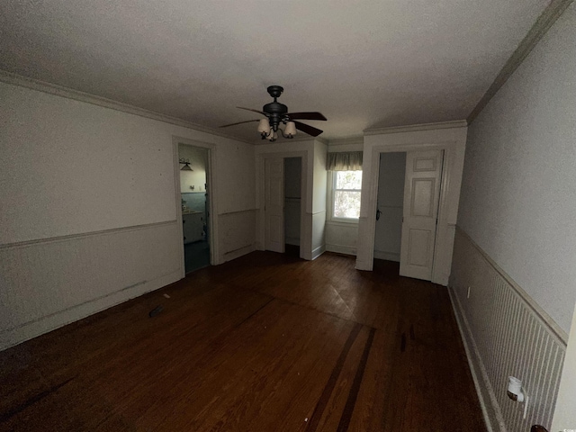 unfurnished bedroom with ceiling fan, ornamental molding, and dark hardwood / wood-style flooring