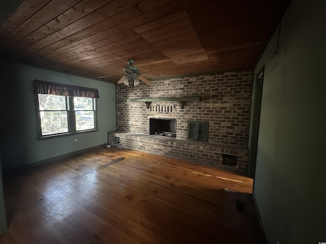 unfurnished living room featuring hardwood / wood-style flooring, ceiling fan, a brick fireplace, and wooden ceiling