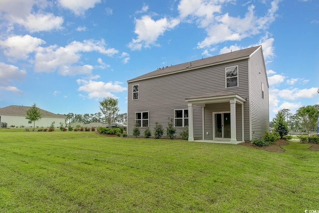 rear view of property featuring a lawn