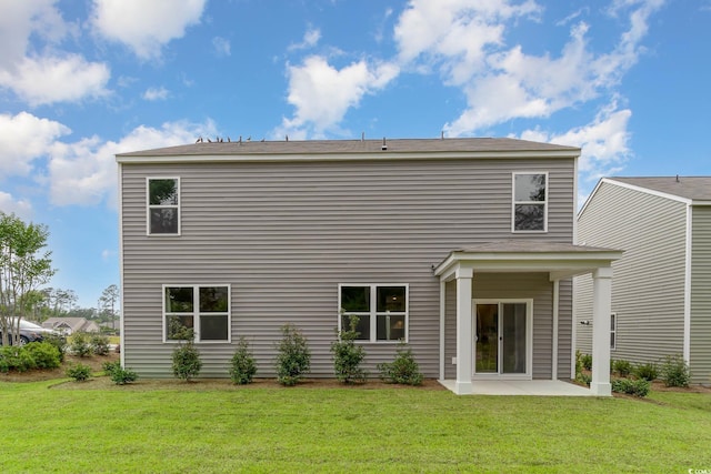 back of house with a yard and a patio