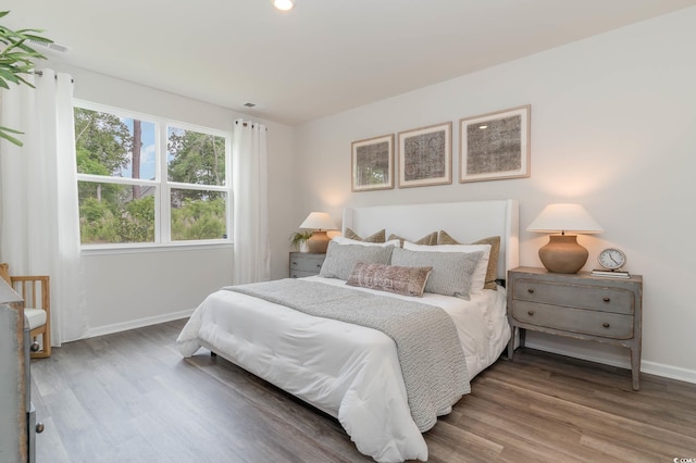 bedroom featuring wood finished floors, baseboards, and recessed lighting