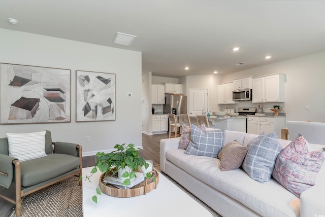 living area with wood finished floors, baseboards, and recessed lighting