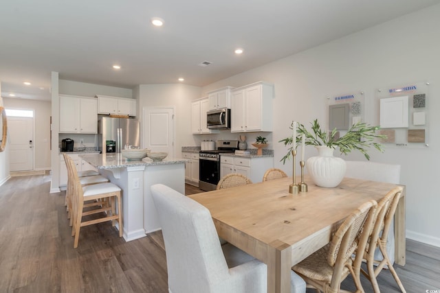 dining room with wood finished floors, baseboards, visible vents, and recessed lighting