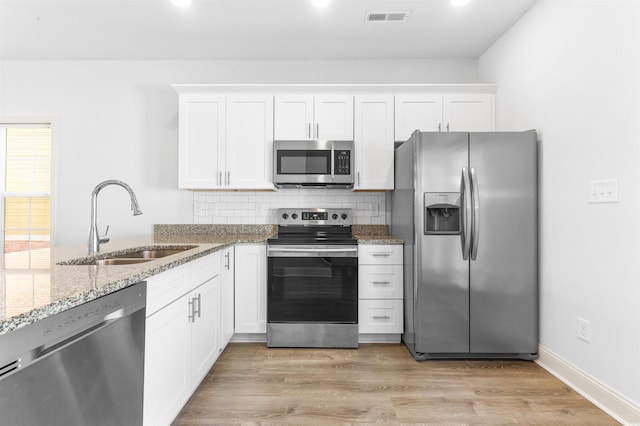763 Moen Pl Unit 763-A, Myrtle Beach, SC 29577 - kitchen with appliances with stainless steel finishes, a sink, light stone countertops, and white cabinetry