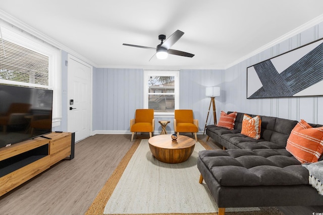 living room featuring ceiling fan, ornamental molding, and wood-type flooring