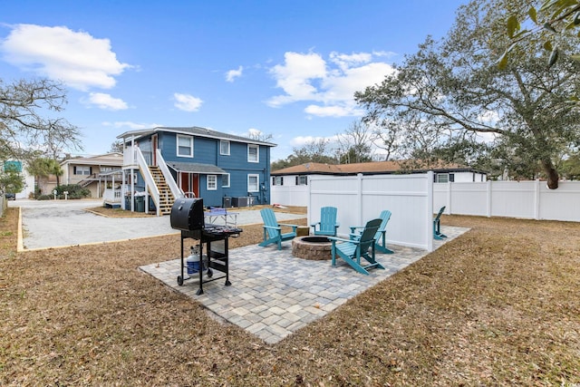 rear view of property with a patio and a fire pit