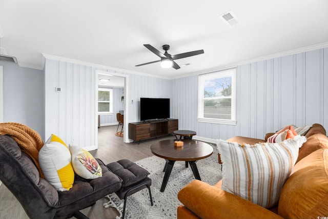 living room with ornamental molding, ceiling fan, and light hardwood / wood-style flooring