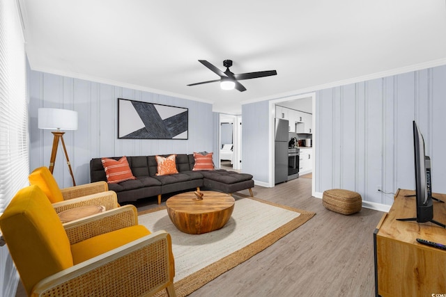 living room featuring crown molding, ceiling fan, and light hardwood / wood-style floors