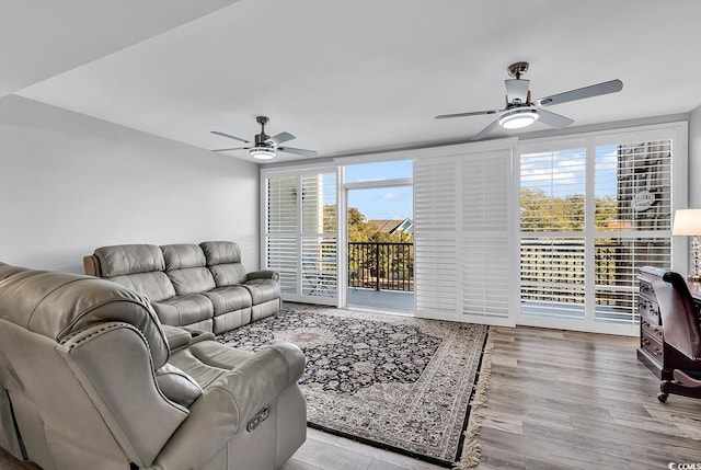 living room with ceiling fan and light hardwood / wood-style flooring