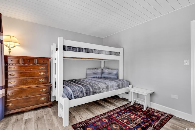 bedroom with light wood-type flooring and wooden ceiling