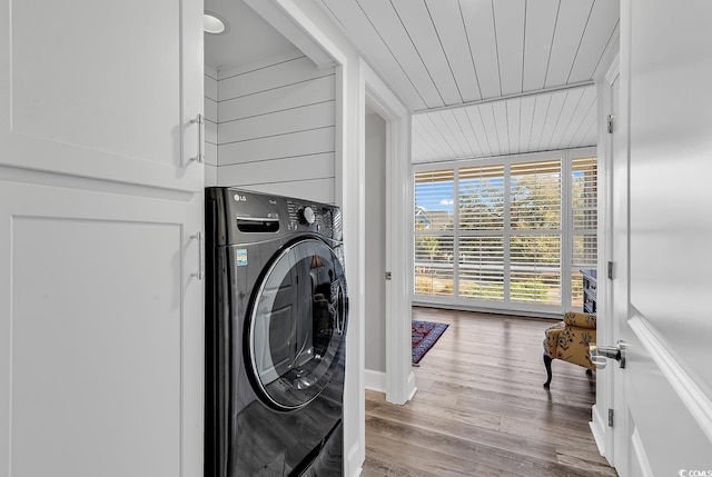 washroom with light wood-type flooring, wood ceiling, and washer / clothes dryer