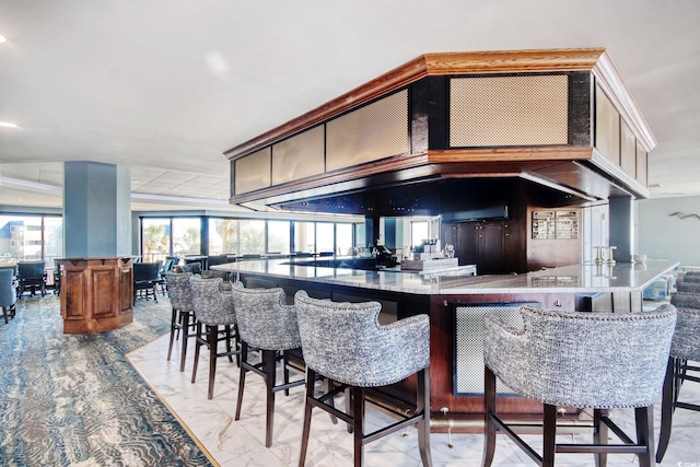 kitchen with dark brown cabinetry, kitchen peninsula, and a kitchen bar