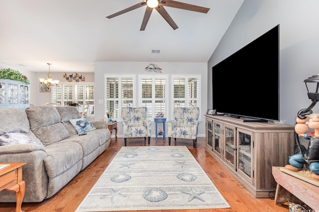 living room featuring ceiling fan with notable chandelier, plenty of natural light, light hardwood / wood-style flooring, and lofted ceiling