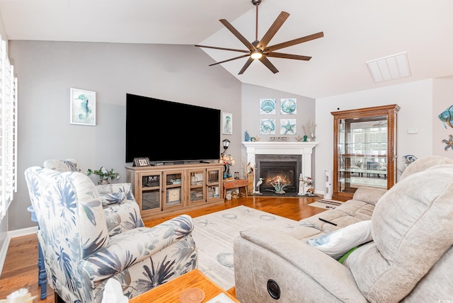 living room featuring hardwood / wood-style flooring, vaulted ceiling, and ceiling fan