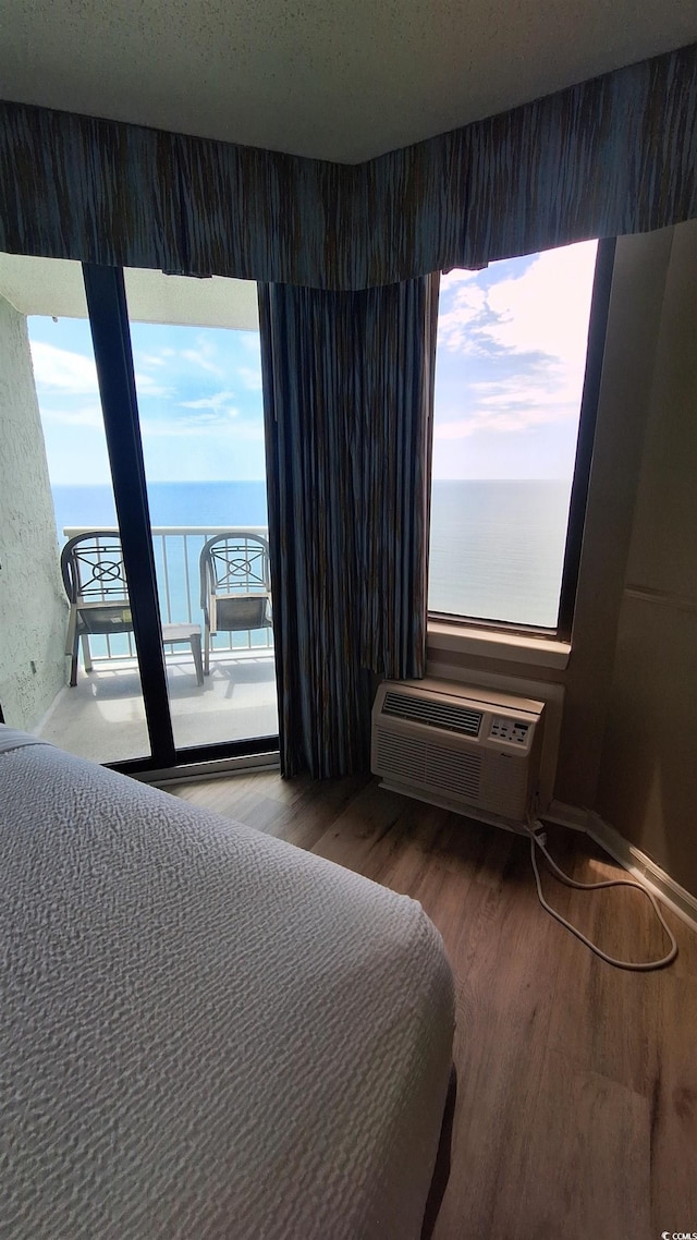 2700 N Ocean Blvd Unit 1854, Myrtle Beach, SC 29577 - bedroom with wood finished floors, access to outside, a wall mounted air conditioner, and a water view